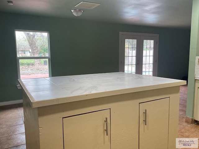 kitchen featuring french doors, cream cabinets, and light tile patterned floors