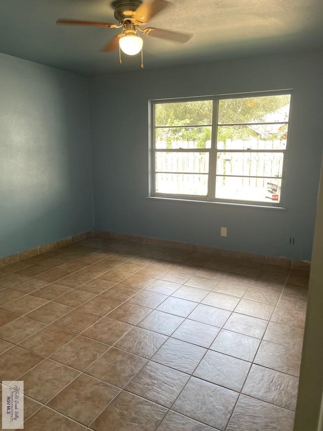 unfurnished room featuring ceiling fan and light tile patterned floors