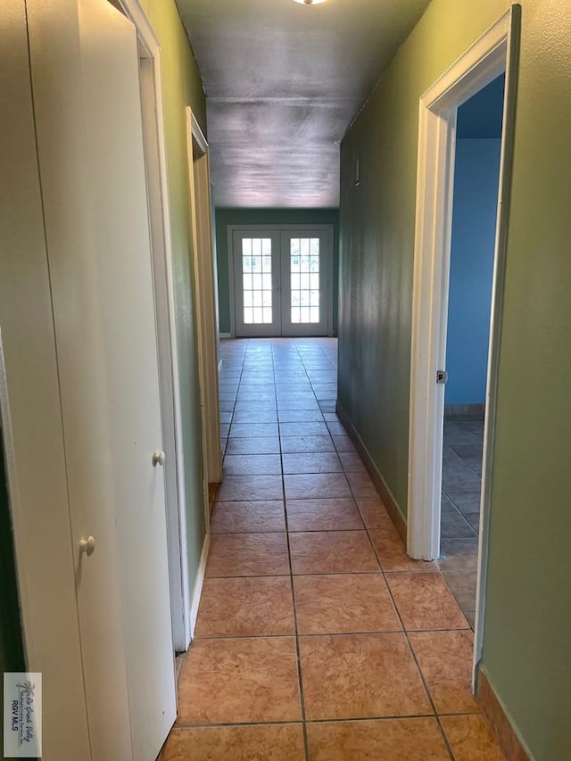 hallway featuring light tile patterned flooring and french doors