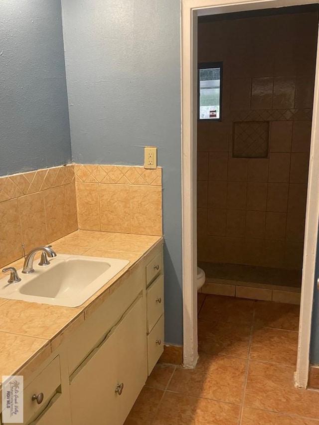 bathroom featuring vanity, backsplash, tile patterned floors, and toilet