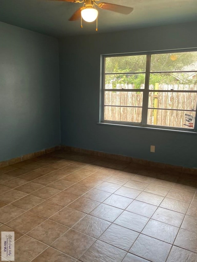 spare room with light tile patterned flooring and ceiling fan