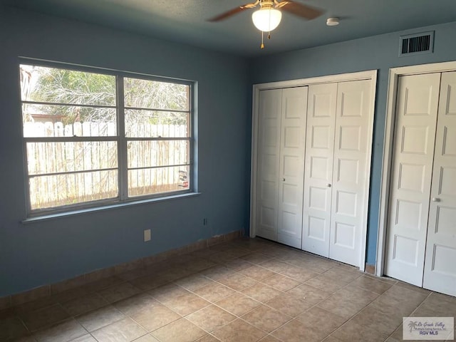 unfurnished bedroom with ceiling fan and light tile patterned flooring