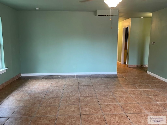 tiled empty room featuring an AC wall unit and ceiling fan