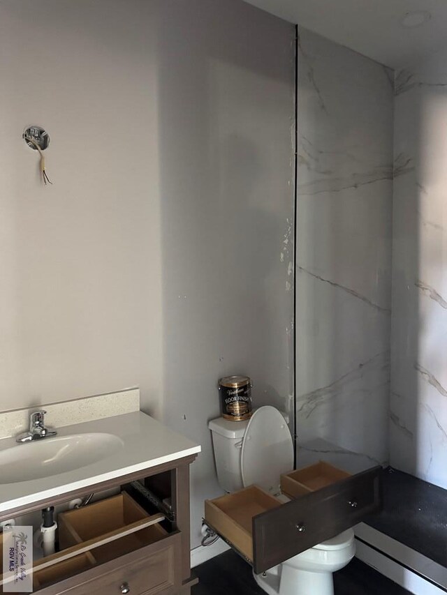 bathroom with walk in shower, vanity, and toilet