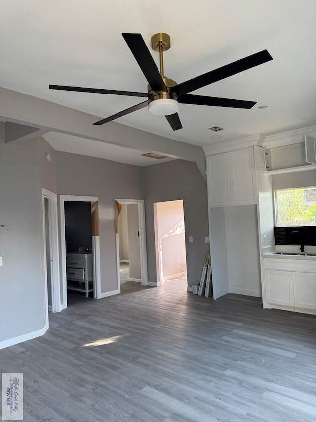 unfurnished living room featuring ceiling fan and wood-type flooring