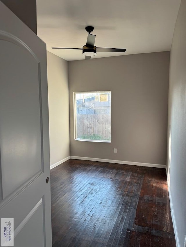 spare room with dark hardwood / wood-style floors and ceiling fan