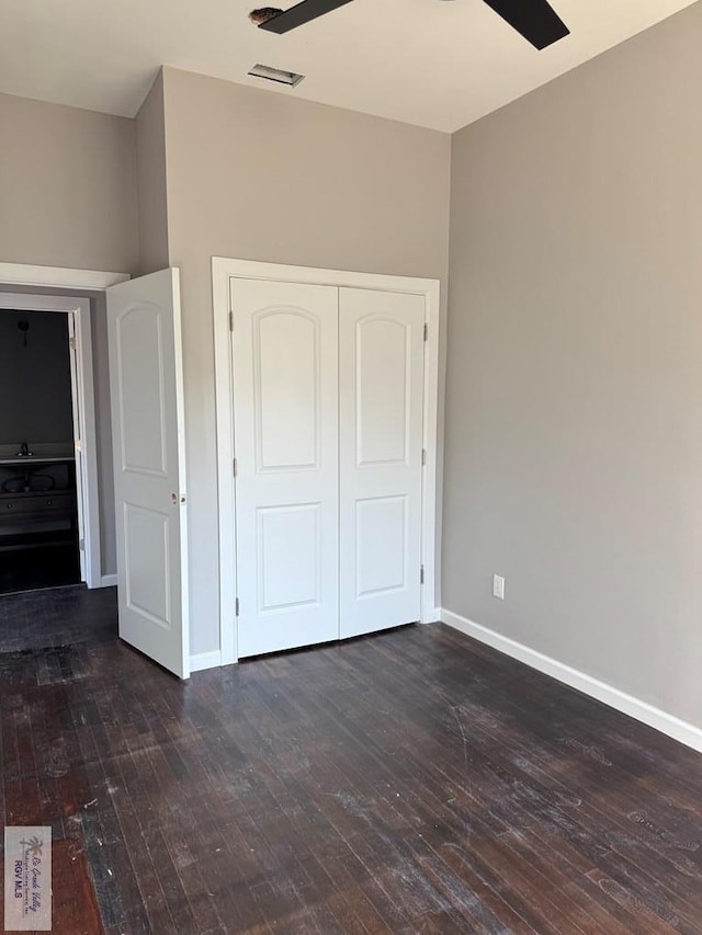 unfurnished bedroom with ceiling fan, dark hardwood / wood-style flooring, and a closet