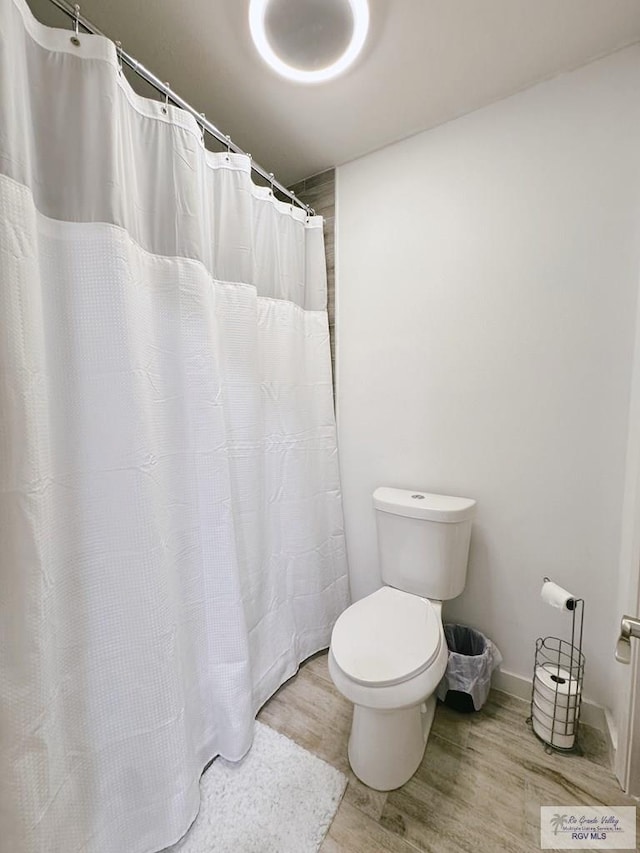 bathroom with hardwood / wood-style floors and toilet