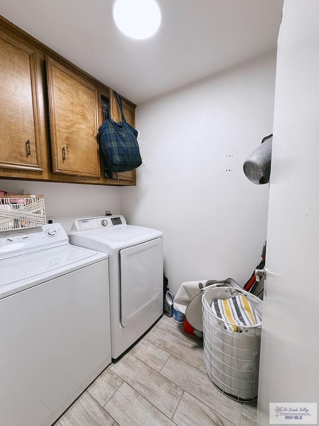 washroom featuring washer and clothes dryer and cabinets