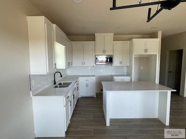 705 W Matz Ave, Harlingen, TX 78550 - kitchen featuring stainless steel microwave, backsplash, wood finish floors, recessed lighting, and a center island