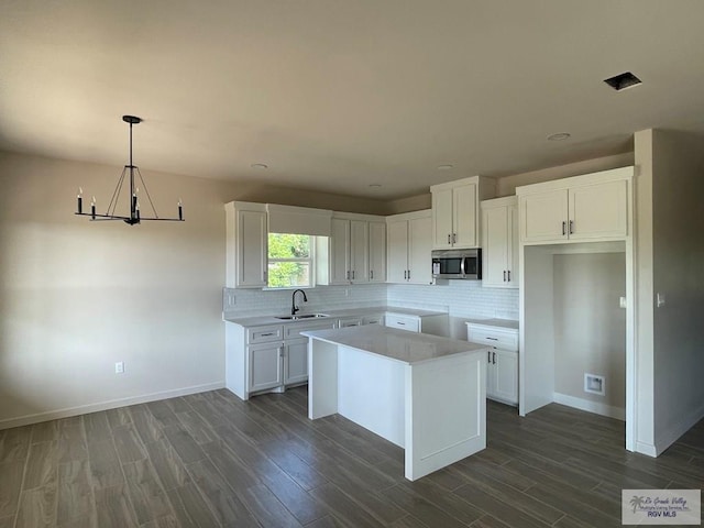 705 W Matz Ave, Harlingen, TX 78550 - kitchen featuring stainless steel microwave, a chandelier, dark wood-style flooring, backsplash, and recessed lighting
