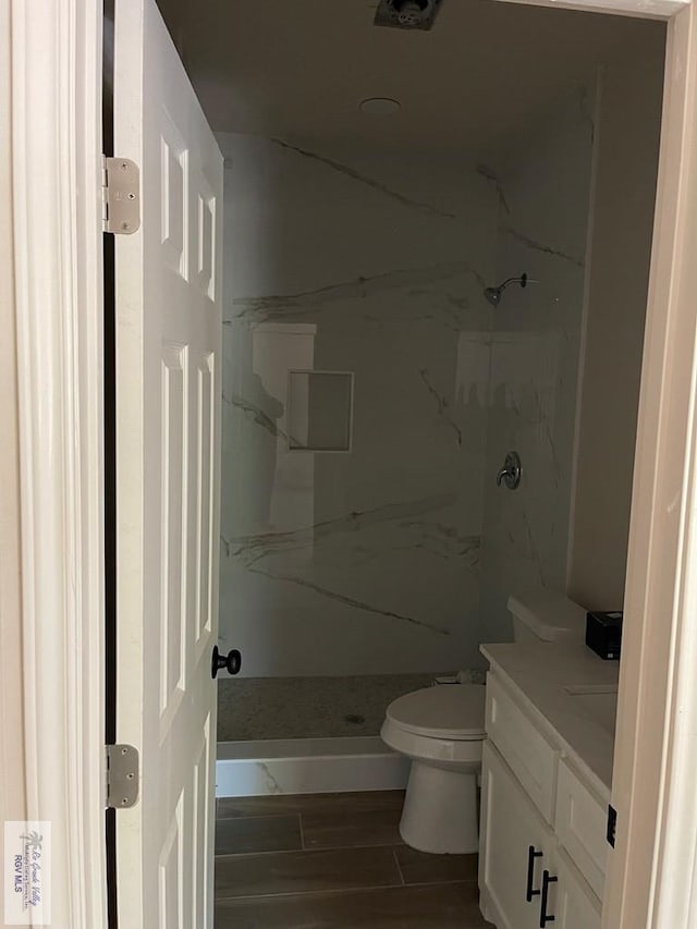 705 W Matz Ave, Harlingen, TX 78550 - bathroom with vanity, a marble finish shower, and wood finished floors