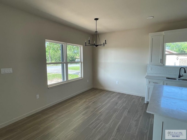 705 W Matz Ave, Harlingen, TX 78550 - unfurnished dining area featuring a chandelier, wood finished floors, and healthy amount of natural light
