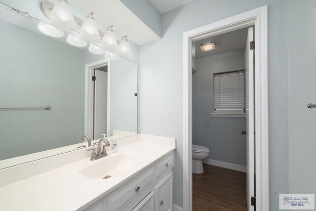 bathroom featuring hardwood / wood-style floors, vanity, and toilet