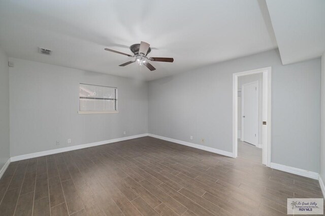 empty room with dark hardwood / wood-style flooring and ceiling fan