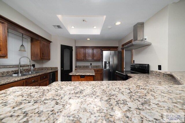 kitchen featuring wall chimney exhaust hood, sink, decorative light fixtures, stainless steel fridge with ice dispenser, and black range with electric stovetop