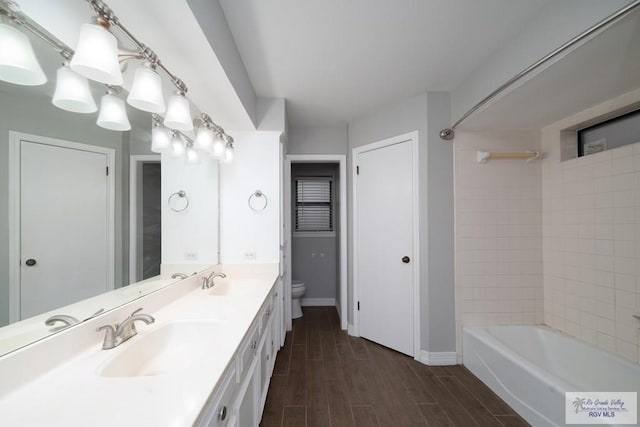 full bathroom with hardwood / wood-style flooring, vanity, toilet, and tiled shower / bath combo