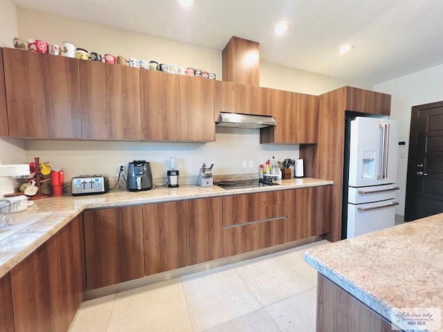 kitchen featuring gas stovetop, light tile patterned floors, extractor fan, and high end white fridge