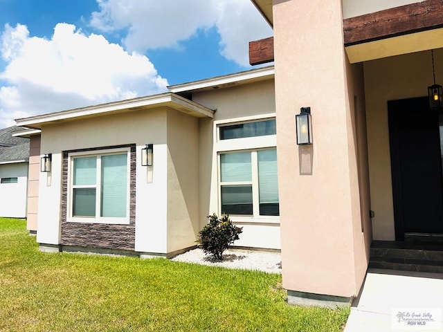 doorway to property with a yard