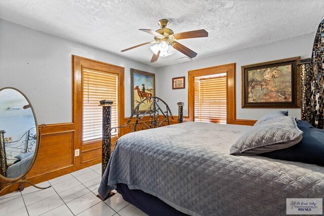 34390 Fm 732, San Benito, TX 78586 - bedroom featuring a ceiling fan, a wainscoted wall, and a textured ceiling