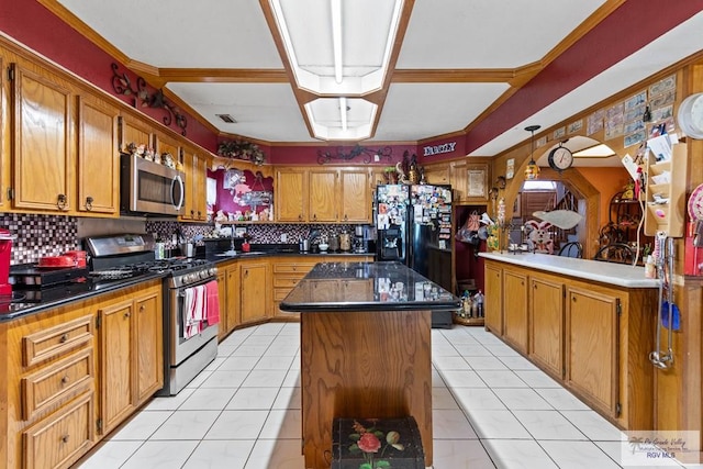 34390 Fm 732, San Benito, TX 78586 - kitchen with light tile patterned floors, decorative backsplash, appliances with stainless steel finishes, dark countertops, and a center island