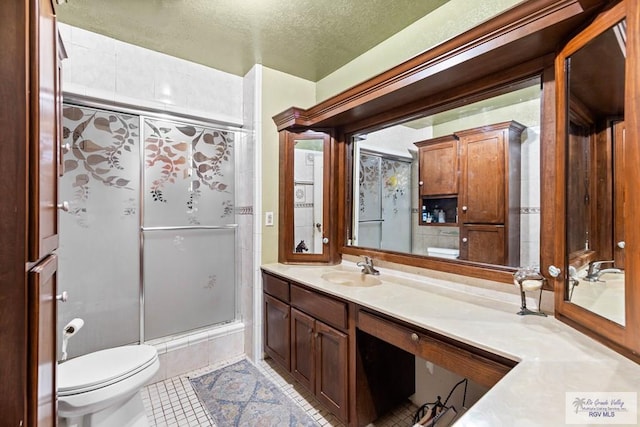 34390 Fm 732, San Benito, TX 78586 - full bath featuring tile patterned flooring, toilet, vanity, an enclosed shower, and a textured ceiling