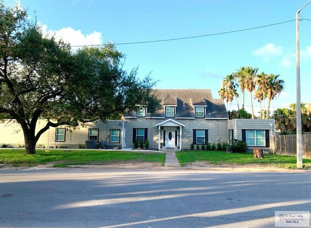 view of front facade featuring a front yard and fence