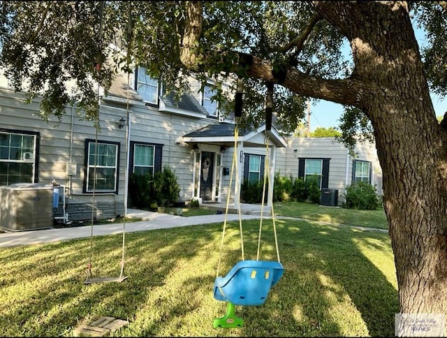 view of front facade with central air condition unit and a front yard