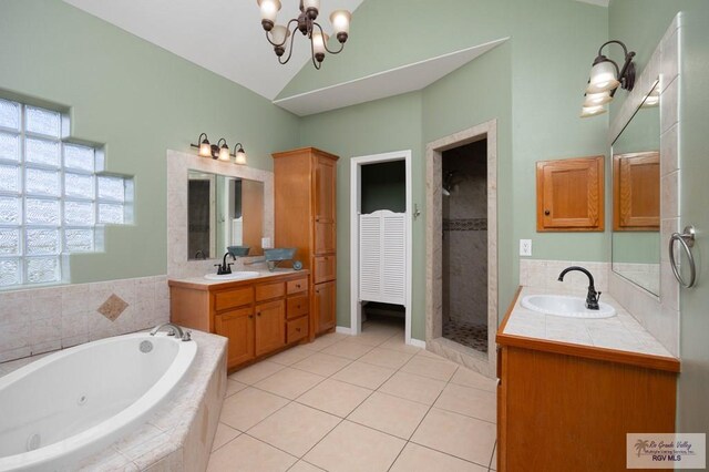 bathroom with tile patterned flooring, vanity, independent shower and bath, and an inviting chandelier