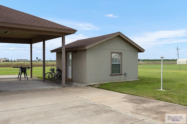 view of home's exterior with an outbuilding, a patio area, and a lawn