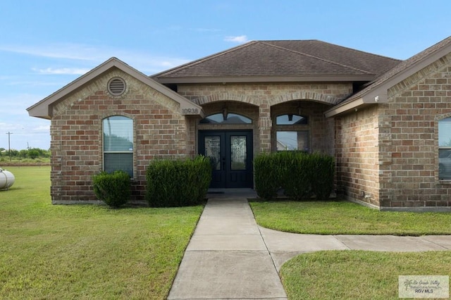 view of exterior entry with a yard