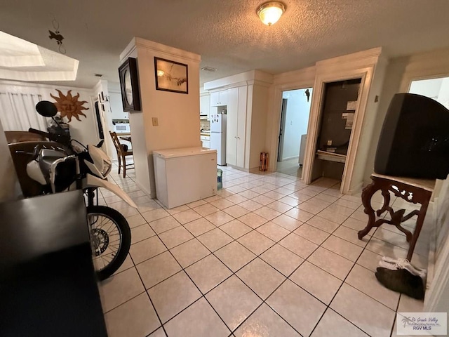 hallway featuring light tile patterned floors and a textured ceiling