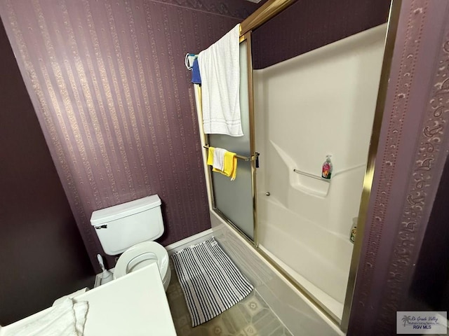 bathroom with toilet and enclosed tub / shower combo