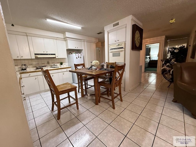 tiled dining room with a textured ceiling