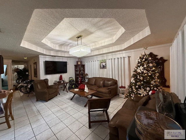 tiled living room with a textured ceiling, a raised ceiling, and a notable chandelier