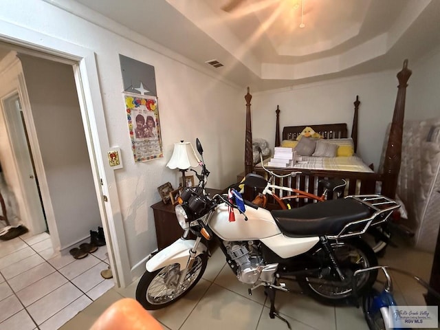 tiled bedroom with a tray ceiling