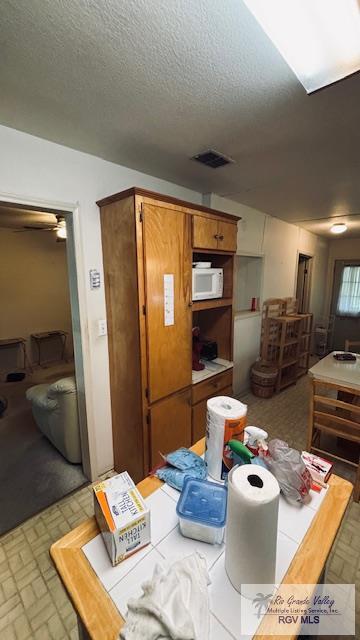 1330 Reagan St Unit 3, San Benito, TX 78586 - dining room featuring visible vents, a textured ceiling, and brick patterned floor