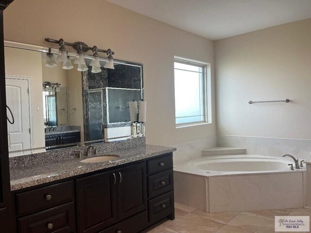 bathroom with tile patterned flooring, shower with separate bathtub, and vanity