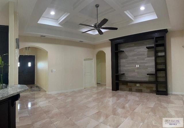 unfurnished living room featuring beamed ceiling, ceiling fan, and coffered ceiling