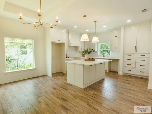 23100 Hidalgo Ave, Harlingen, TX 78552 - kitchen featuring a kitchen island, light wood finished floors, white cabinetry, recessed lighting, and custom range hood