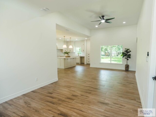 23100 Hidalgo Ave, Harlingen, TX 78552 - unfurnished living room with ceiling fan, light wood-style floors, baseboards, and recessed lighting