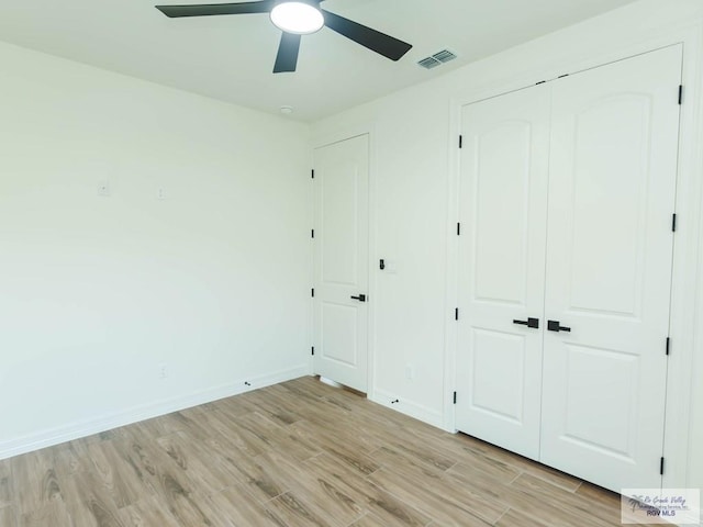 23100 Hidalgo Ave, Harlingen, TX 78552 - unfurnished bedroom with light wood-type flooring, baseboards, a closet, and ceiling fan