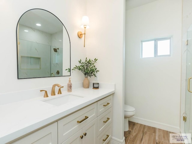 23100 Hidalgo Ave, Harlingen, TX 78552 - bathroom featuring vanity, toilet, a shower stall, and baseboards