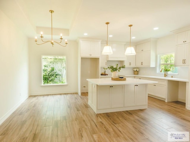 23100 Hidalgo Ave, Harlingen, TX 78552 - kitchen with light wood-type flooring, a center island, a chandelier, light countertops, and recessed lighting