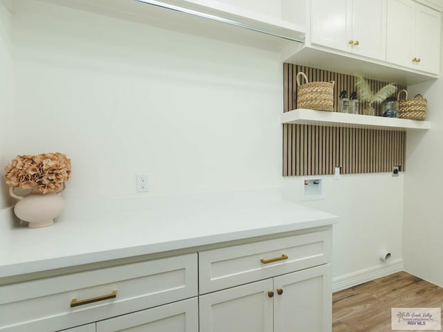 23100 Hidalgo Ave, Harlingen, TX 78552 - washroom featuring light wood-type flooring, hookup for a washing machine, cabinet space, and baseboards
