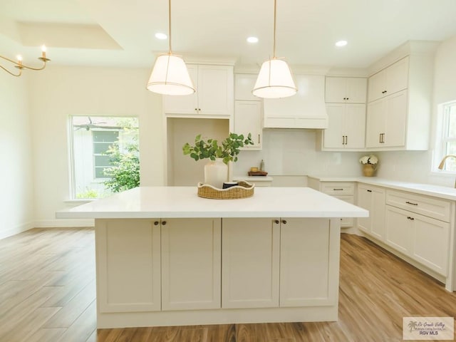 23100 Hidalgo Ave, Harlingen, TX 78552 - kitchen with a center island, light wood finished floors, white cabinets, recessed lighting, and decorative light fixtures