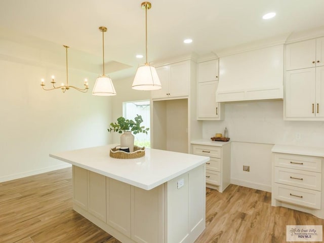 23100 Hidalgo Ave, Harlingen, TX 78552 - kitchen featuring light wood-style flooring, a center island, baseboards, white cabinetry, and recessed lighting