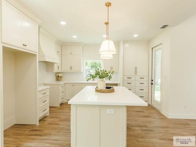 23100 Hidalgo Ave, Harlingen, TX 78552 - kitchen featuring a center island, light wood-style floors, recessed lighting, white cabinets, and decorative light fixtures