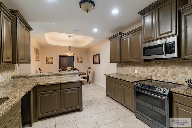 kitchen with kitchen peninsula, tasteful backsplash, light stone counters, dark brown cabinetry, and electric range