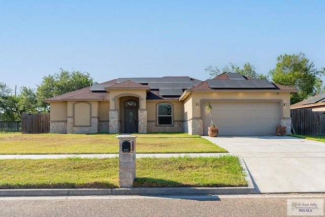 view of front facade with a front lawn, a garage, and solar panels